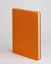 Orange diary standing on table on white background. Side view