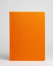Orange diary in standing view on table on white background. Frontside