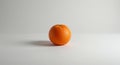 Orange with a dimpled surface and vibrant color rests on a white surface against a lig Royalty Free Stock Photo