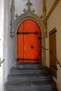 Orange arched door entrance with steps of historic building