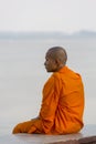 Orange dressed Cambodian monk looking at the Mekong, Phnom Penh