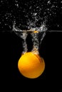 Orange drowns in water on a black background. Citrus with water splashes