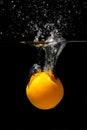 Orange drowns in water on a black background. Citrus with water splashes