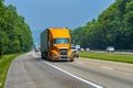 Orange Eighteen-Wheeler In Traffic On Interstate Highway