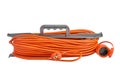 Orange electrical extension cord with plug and socket wrapped around plastic holder isolated on white background Royalty Free Stock Photo