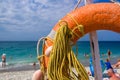 Orange emergency lifebuoy on a pebbly sea beach, close up