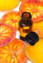 Orange essential oil in amber bottle with red oranges Royalty Free Stock Photo