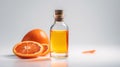 Orange essential oil in a glass bottle with fresh fruits on a gray background