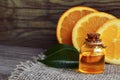 Orange essential oil in a glass bottle and fresh fruits on old wooden table.Citrus oil for skin care, spa, wellness, massage. Royalty Free Stock Photo