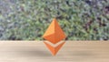 Orange Ethereum gold sign icon on wood table on leaves background. 3d render isolated illustration, cryptocurrency, crypto,