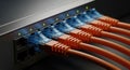 Close up view of multiple orange ethernet cables plugged into a network switch with illuminated ports Royalty Free Stock Photo