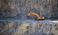 Orange excavator, digger in a granite quarry Royalty Free Stock Photo