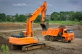 Orange excavator and orange dump truck at a construction site Royalty Free Stock Photo