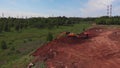 Orange excavator fills workbody of tipper truck with dirt