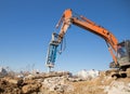 Orange excavator with an industrial hydraulic hammer against a blue sky Royalty Free Stock Photo