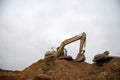 Orange excavator machine on earthworks in sandpit at construction site. Backhoe digs ground for construct foundantion Royalty Free Stock Photo
