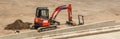 Orange excavator parked next to concrete platform