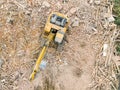 Orange excavator on pile of debris of destroyed building. aerial