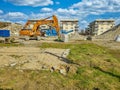 Orange excavator on the site of bilding, dismantling of the building Royalty Free Stock Photo