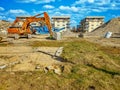 Orange excavator on the site of bilding, dismantling of the building Royalty Free Stock Photo