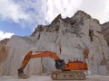 Orange Excavator in a white marble quarry in Carrara