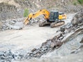 Orange excavator working on earthmoving at open pit mining Royalty Free Stock Photo