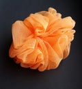 Orange exfoliating bath sponge for a relaxing at-home spa experience. Closeup of a bath sponge.