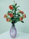 Orange fabric roses arranged in purple vases to decorate the room. Royalty Free Stock Photo