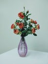 Orange fabric roses arranged in purple vases to decorate the room. Royalty Free Stock Photo