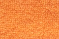 Orange fabric texture. Close-up of a orange fluffy terry bath towel or textile backround. Macro photograph. Beautiful bright Royalty Free Stock Photo