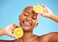 Orange, face and nutrition with a model black woman in studio on a blue background for treatment. Beauty, skincare and