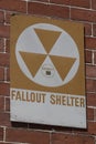 Orange Fallout Shelter sign on a brick wall. With global instability, Fallout Shelters may become more popular