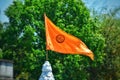 An orange flag is waving at the peak of a temple