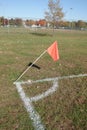 Orange flag on a white post on a grassy field by white base lines Royalty Free Stock Photo