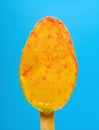 an orange flavor popsicle starts melting on a blue background Royalty Free Stock Photo