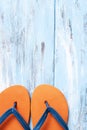 Orange flip-flops on a blue rustic wooden surface Royalty Free Stock Photo