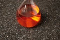 Chemical Orange Flask on Ruberoid Grain Surface