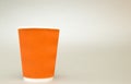 Orange fluted paper cup for coffee stands on white background