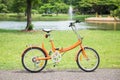 Orange folding bicycles in park