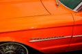 Orange Ford Thunderbird close up of front wing, and hood, wheel tire, with Thunderbird badge