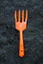 Orange fork harrows on black soil ground. background and texture Royalty Free Stock Photo