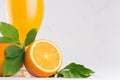 Orange fresh citrus juice with ripe oranges slice macro texture and green leaf on soft white wood board, copy space. Royalty Free Stock Photo