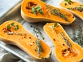 Orange fresh pumpkin cooking with spice and herbs. cut pumpkin slices on a baking sheet. Fresh orange muscat gourd cut in half, re