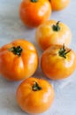 Orange fresh ripe tomatoes on a white stone background. Close up Royalty Free Stock Photo