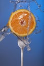 Orange fruit fork water splash blue concept health Royalty Free Stock Photo