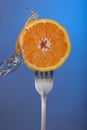 Orange fruit fork water splash blue concept health Royalty Free Stock Photo