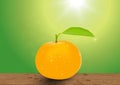 Orange fruit and leaf with water drops on wooden tabletop on blurred green nature bokeh background Royalty Free Stock Photo