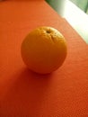 An orange fruit on an orange mat
