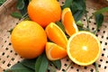 Orange fruit pile half and slice with green leaves fruits or vegetables on wicker tray 