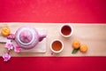 Orange fruit, Pink cherry blossom and teapot with Copy space for text on red texture background, Chinese new year background Royalty Free Stock Photo